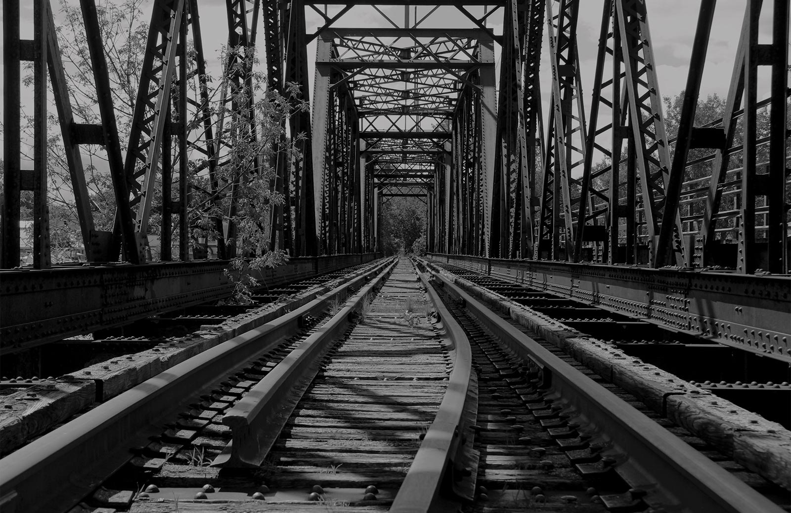image en noir et blanc de voies ferrées et d'un tréteau